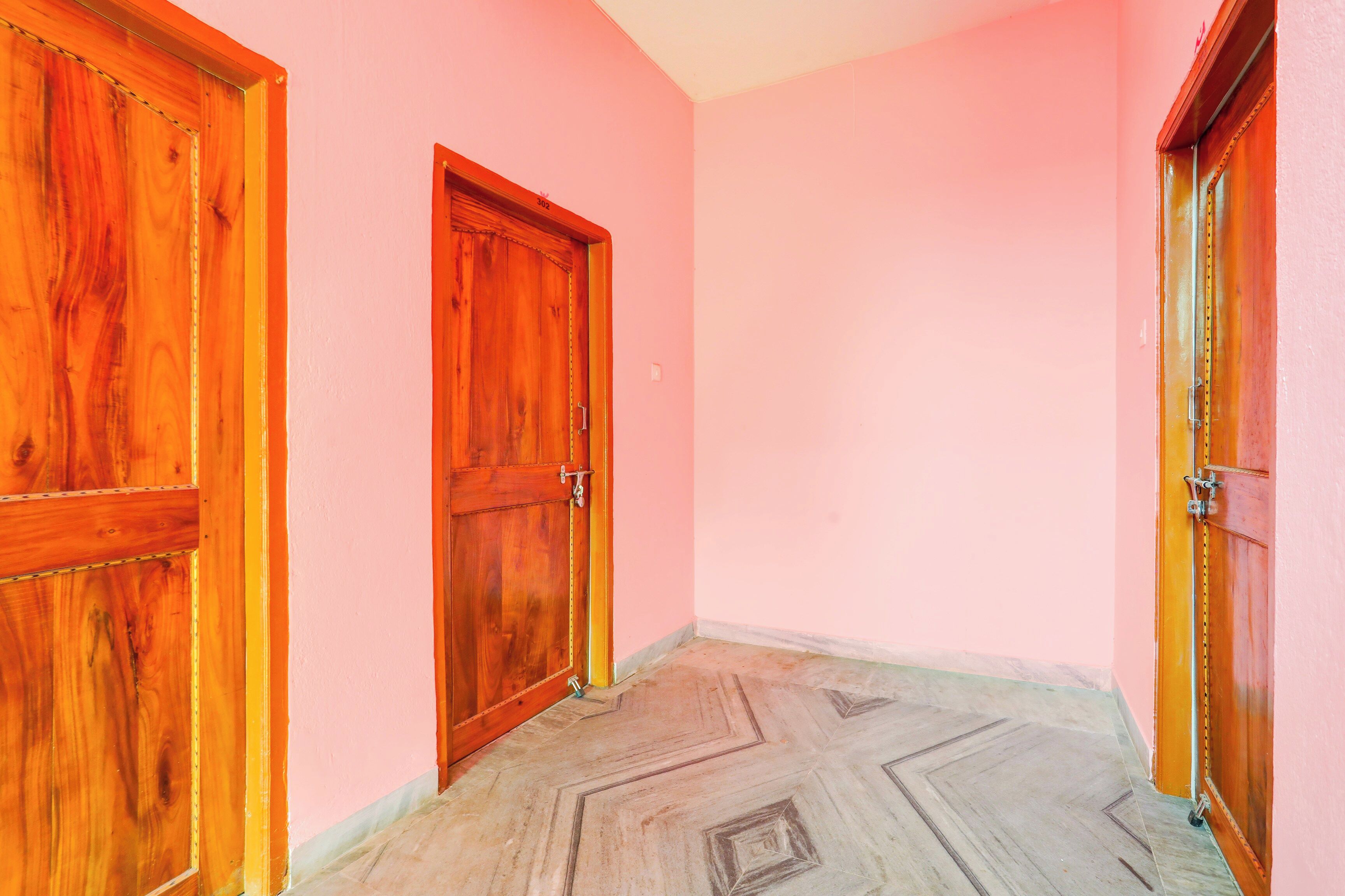 A hallway with two wooden doors and a patterned floor.