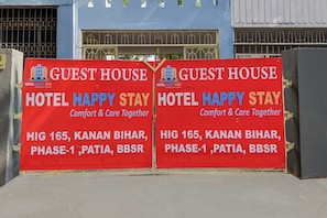 Two red signs for Hotel Happy Stay, indicating location at Hig 165, Kanan Bihar, Phase-1, Patia, BBSR. - Hotel O by OYO Happy Stay (Bhubaneswar)