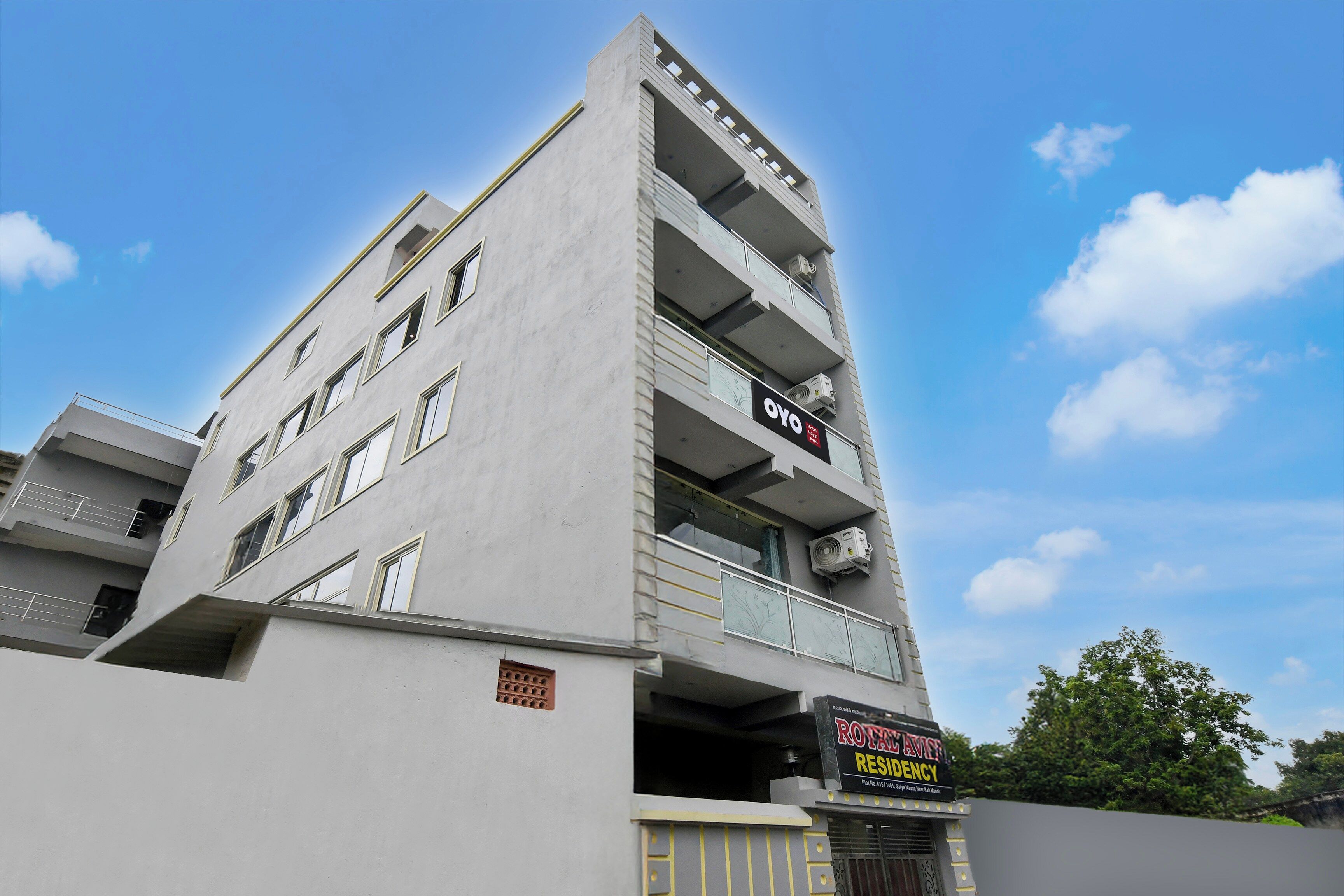 A multi-story building with a sign for 'OYO Hotel & Residency' and another sign for 'Royal Avenue Residency'.