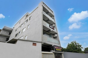 Ein mehrstöckiges Gebäude mit einem Schild für 'OYO Hotel & Residency' und einem weiteren Schild für 'Royal Avenue Residency'.