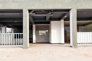A building entrance with a closed metal gate, concrete pillars, and a paved ground. - Hotel O Sayhallo Citadel (Bhubaneswar)