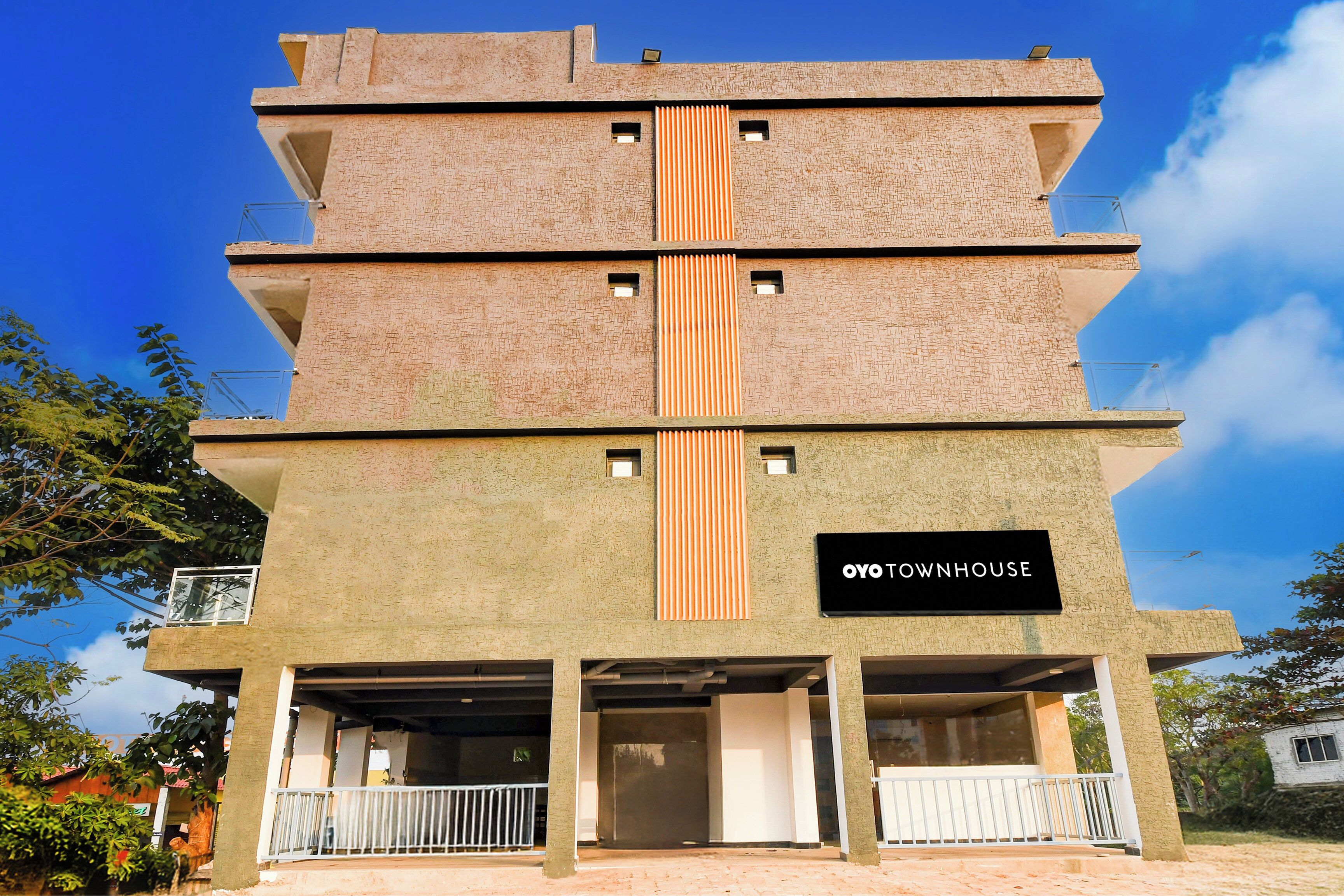 Un edificio a più piani con un cartello che riporta la scritta 'OYO TOWNHOUSE'.