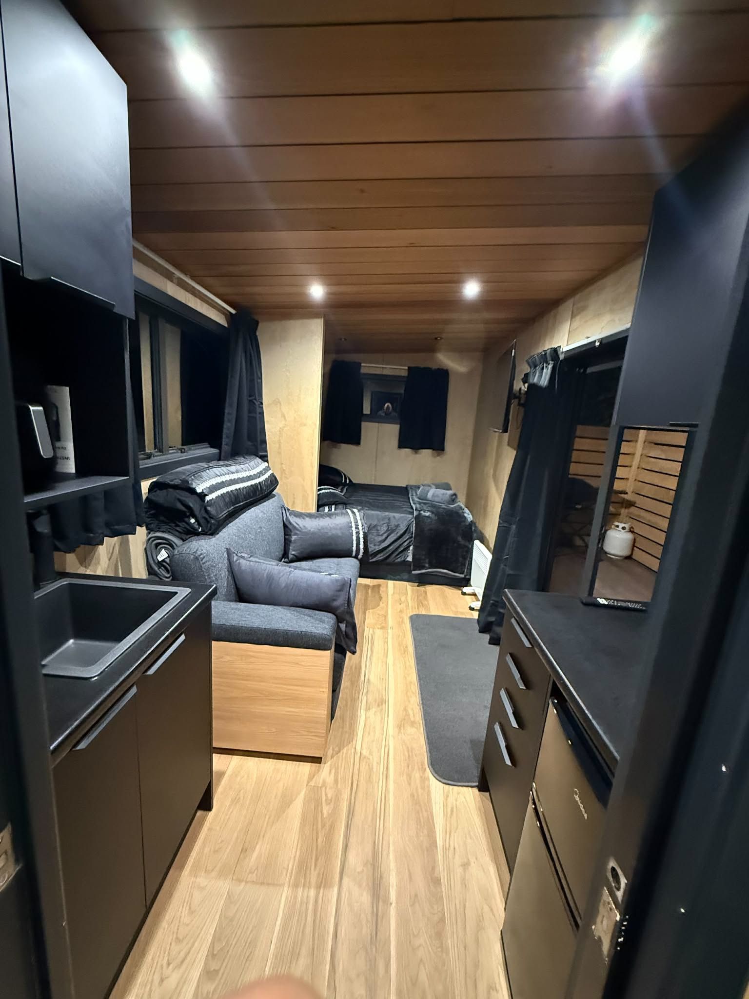 Ein kompaktes Wohnmobil-Interieur mit Küchenzeile, Sitzgelegenheit und Stauraumschränken.