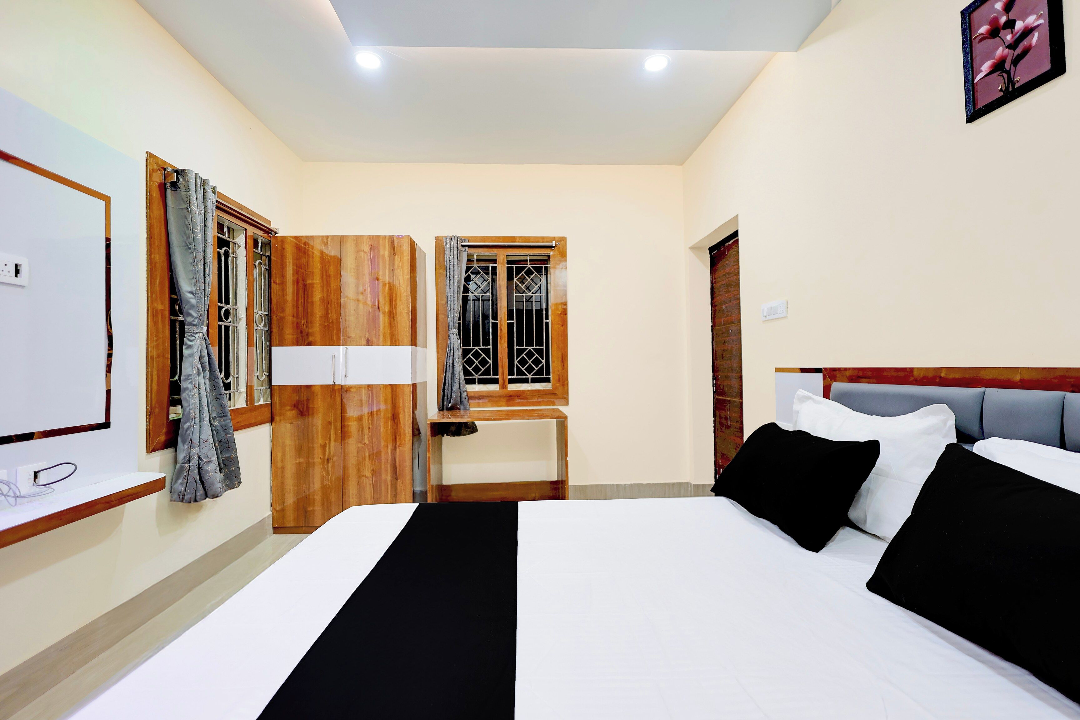 A hotel room with a bed, a desk, and a wardrobe.