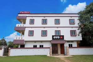 Un hotel de varios pisos con balcones, un letrero que dice 'ROYAL KALINGA' en la parte superior y 'OYO HOTEL' en la fachada.