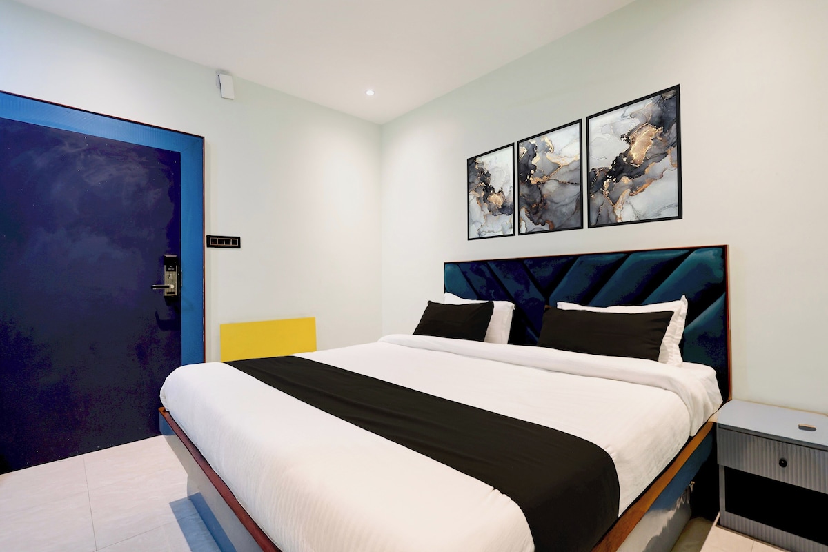 A modern bedroom with a large bed, a nightstand, and a door.