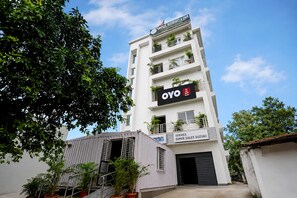 Un immeuble à plusieurs étages dont la façade porte une enseigne indiquant « Skyplek Residency & Cafe » et « OYO Guest House ».