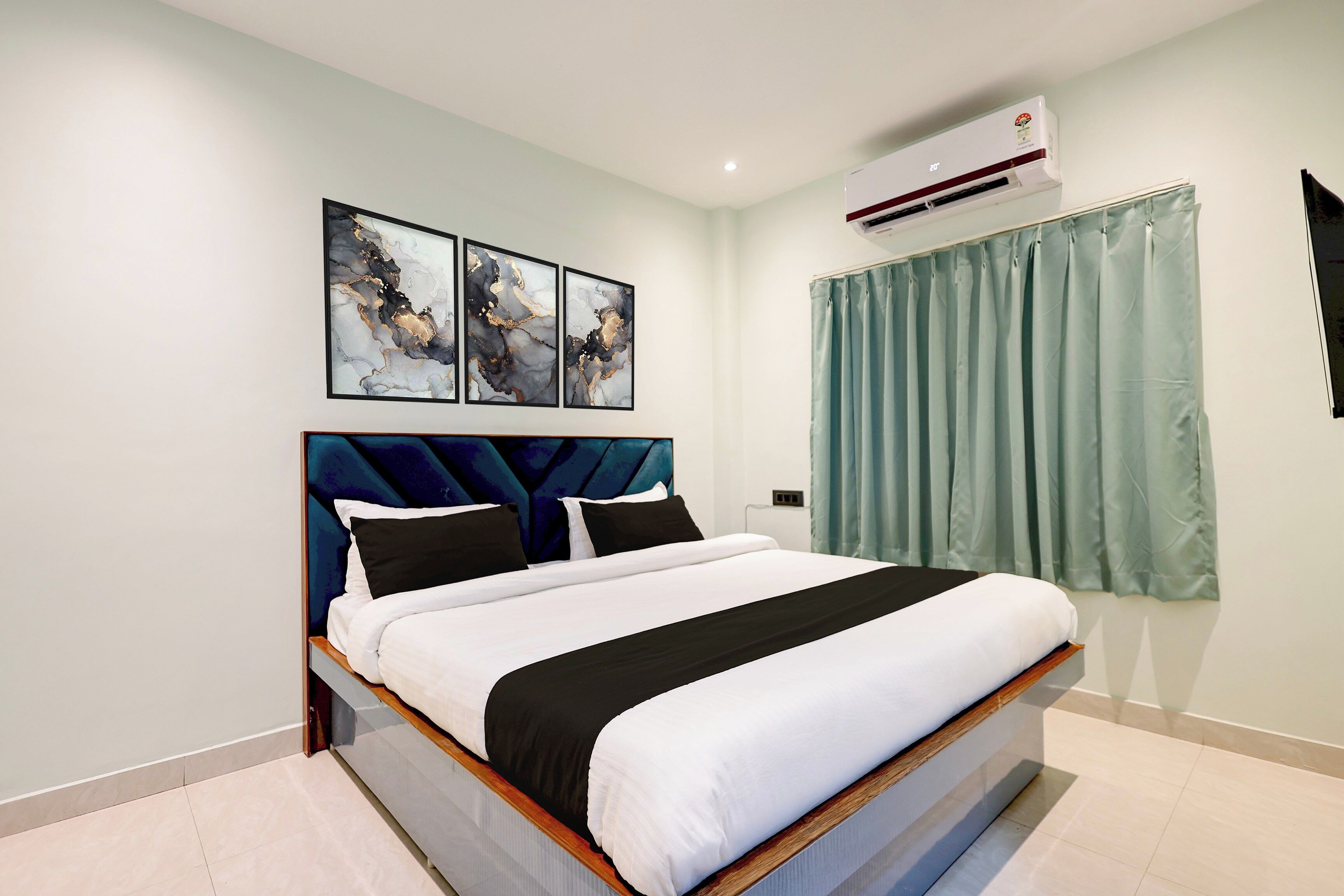 A bedroom with a bed, a headboard, a wall-mounted air conditioner, and a window with curtains.