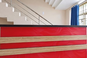 Eine Treppe mit einer beigen Wand und einem roten Wandpaneel unten.
