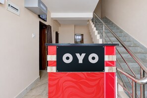 A hotel reception area with a red and black sign that reads 'OYO'. - Hotel O Temple City Guest House (Bhubaneswar)