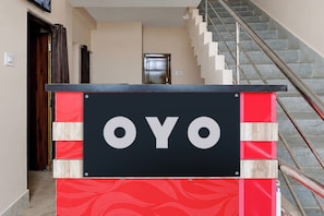 Ein Hotel Eingang mit einem Schild mit der Aufschrift 'OYO' und einer Treppe, die zu den oberen Stockwerken führt.