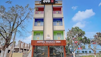 Un hotel de varios pisos con un letrero que indica que es el Hotel OYO Dhauli Inn.