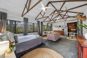 Ein geräumiges Zimmer mit einem großen Bett, einem Sofa, einem Esstisch und einer Küchenzeile.
