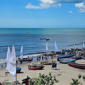 Una spiaggia con diverse barche e persone.