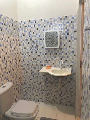Un bagno piccolo con il water, lavandino e doccia.