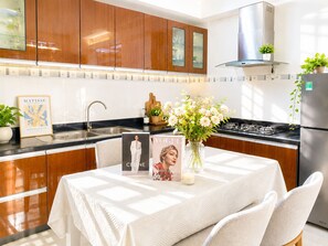 A modern kitchen with wooden cabinets, a stainless steel sink, and a gas stove. - Spacious 2BR Apt near Ben Thanh Market & D1 Free Wifi (Thành phố Hồ Chí Minh)