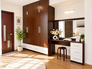 A modern bedroom with a large wardrobe, a bedside table, a mirror, and a potted plant. - Spacious 2BR Apt near Ben Thanh Market & D1 Free Wifi (Thành phố Hồ Chí Minh)