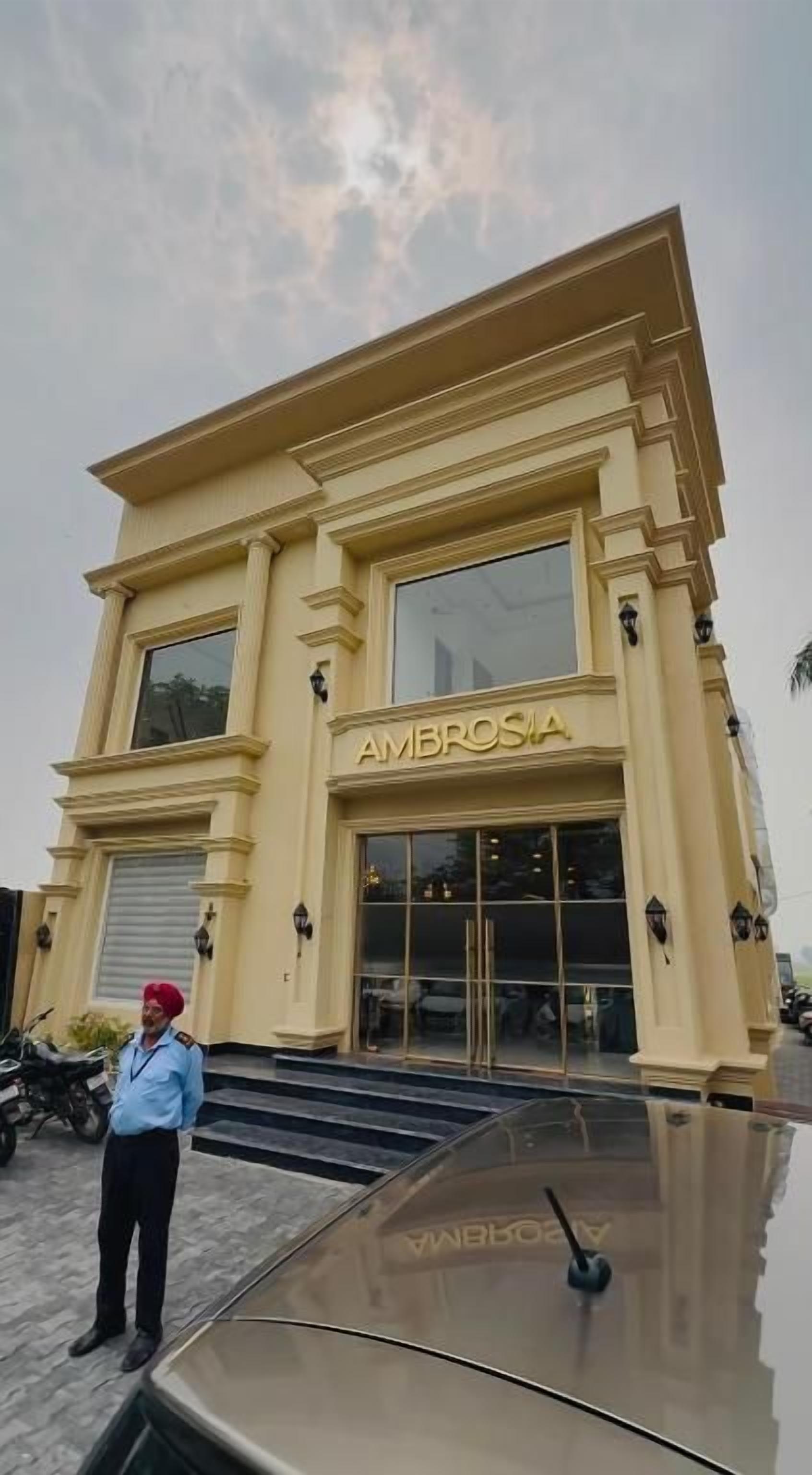 Um edifício com uma placa indicando 'AMBROSIA' e uma pessoa em frente.