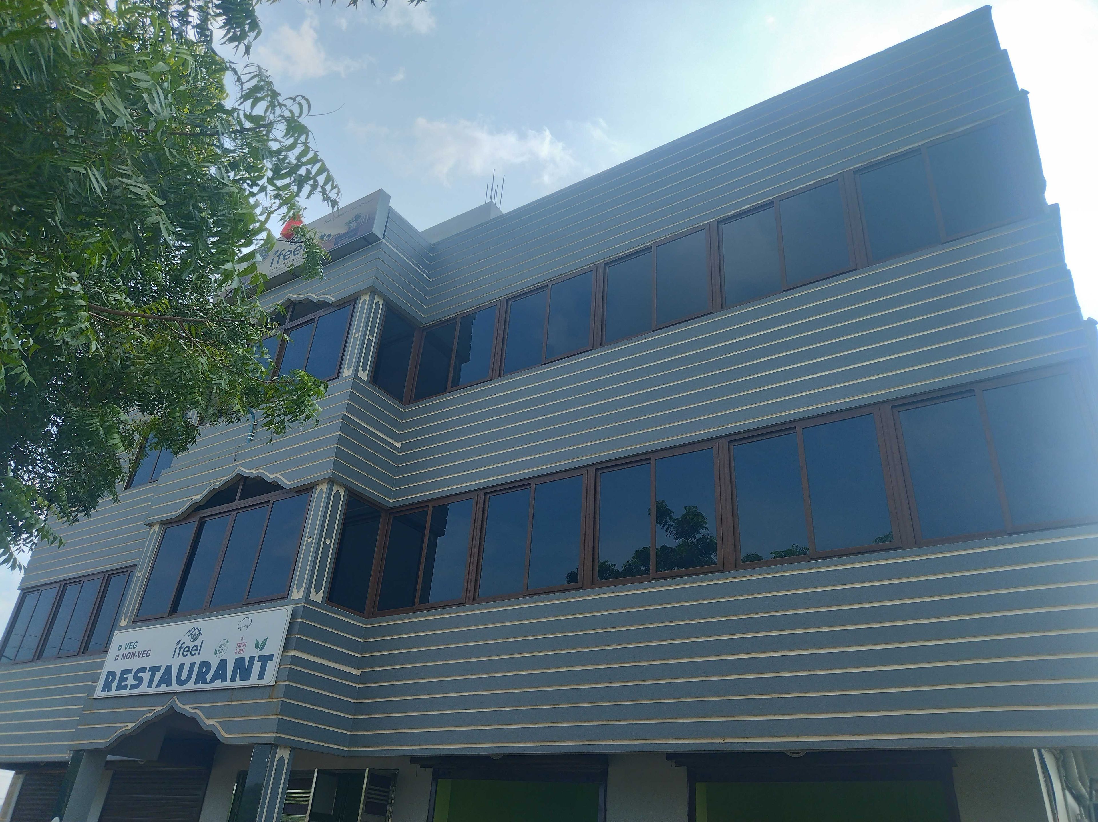 Un edificio moderno con un letrero de restaurante, ventanas amplias y una entrada en esquina.
