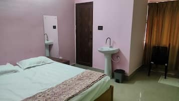 Un dormitorio con cama, dos lavamanos, una puerta y un equipo de aire acondicionado.