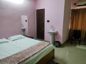A bedroom with a bed, two sinks, a door, and an air conditioning unit. - Hotel O I Feel Guest House (Khordha)