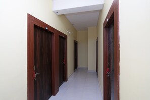 A corridor with wooden doors, numbered 107, leading to individual rooms. - Hotel O Ezy Sleep (Bhubaneswar)