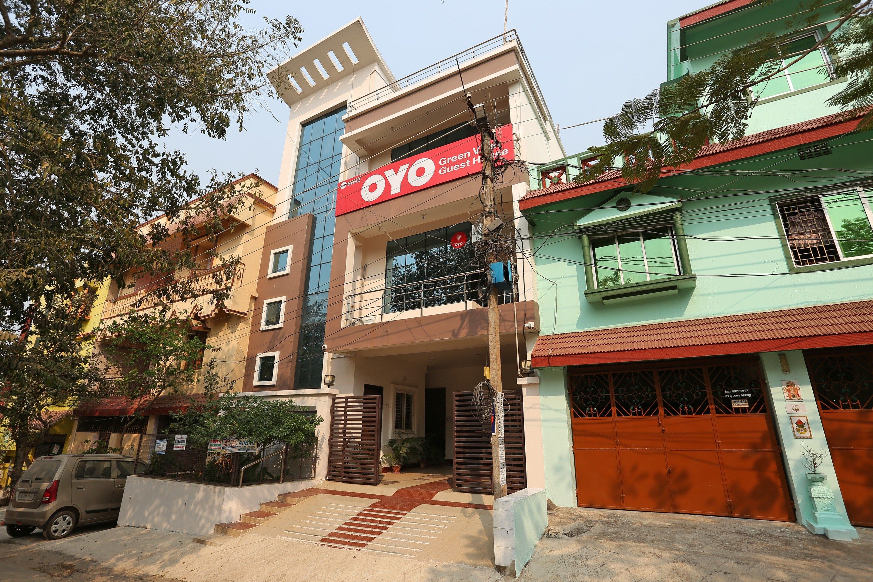 A multi-story building with a prominent red sign for 'OYO Guest House'.