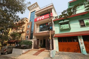A multi-story building with a prominent red sign for 'OYO Guest House'. - Hotel O Mahadev Palace (Bhubaneswar)