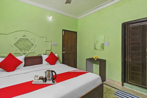 Una habitación de hotel con una cama, una mesita de noche, una puerta y una ventana.