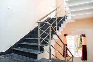 Una escalera con barandillas metálicas y escalones negros que conducen a una plataforma.
