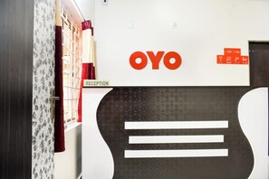 Un área de recepción con un letrero que dice 'OYO' y un letrero adicional que indica 'Recepción'.