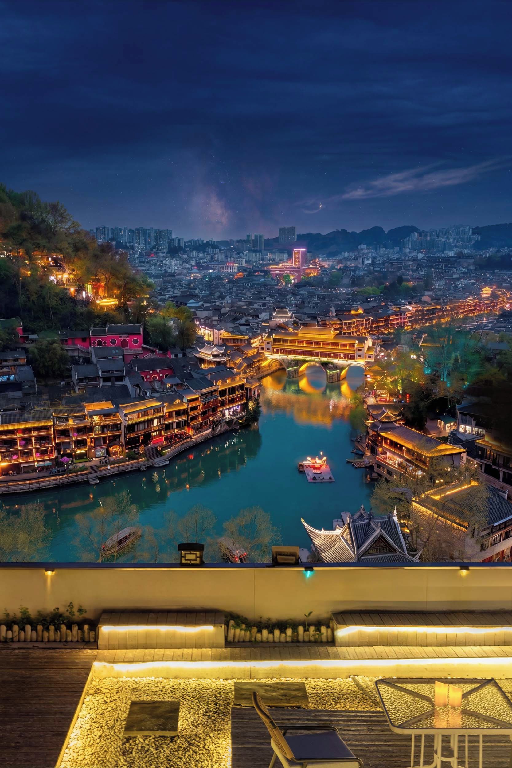A riverside town with traditional buildings and a modern skyline at night.
