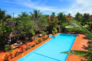 Una piscina rodeada de exuberante vegetación y palmeras.