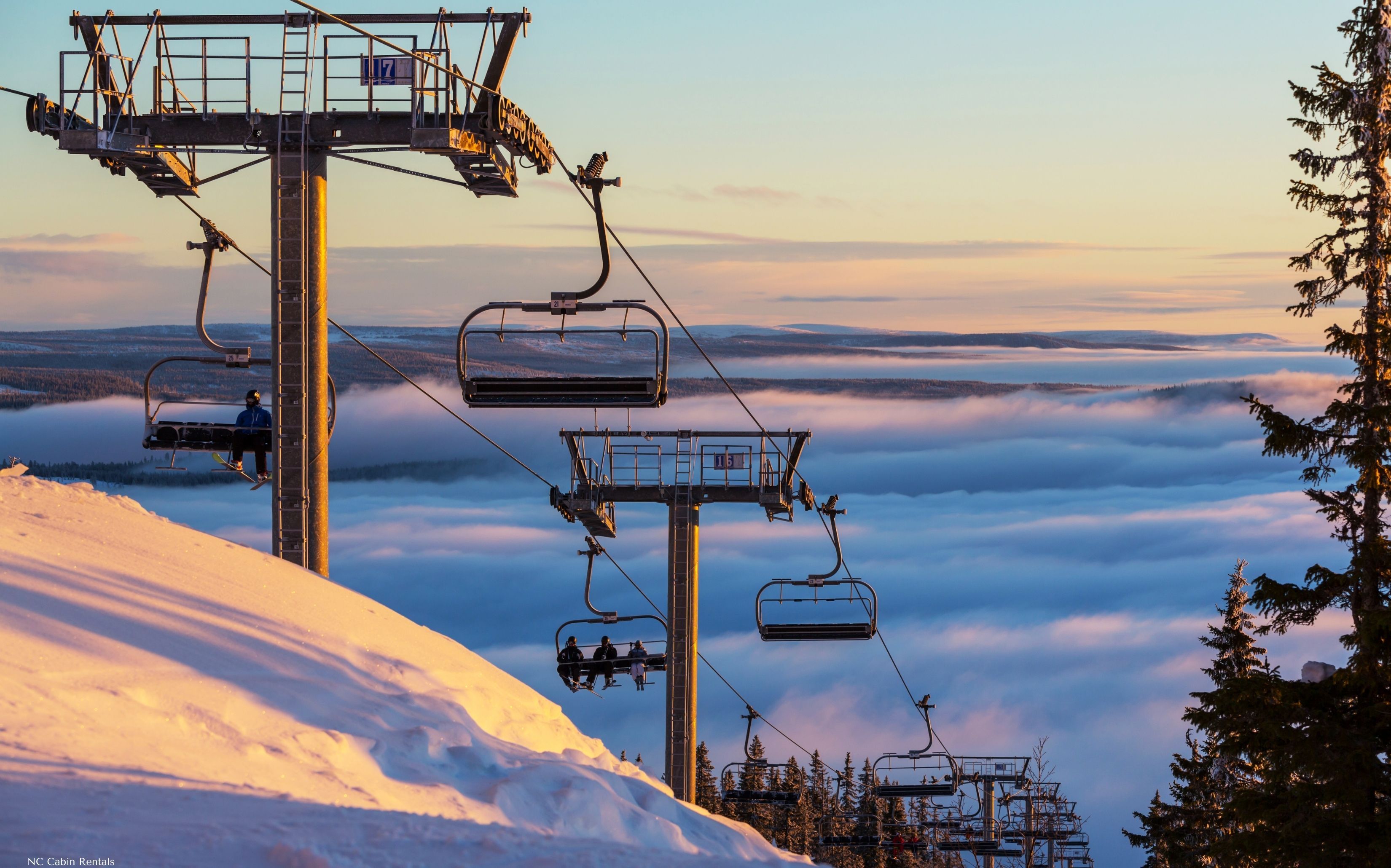 Scenic ski lift with breathtaking mountain views above the clouds