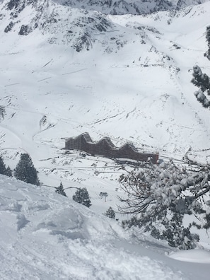 Een berglandschap bedekt met sneeuw, met een gebouw in traditionele bouwstijl.