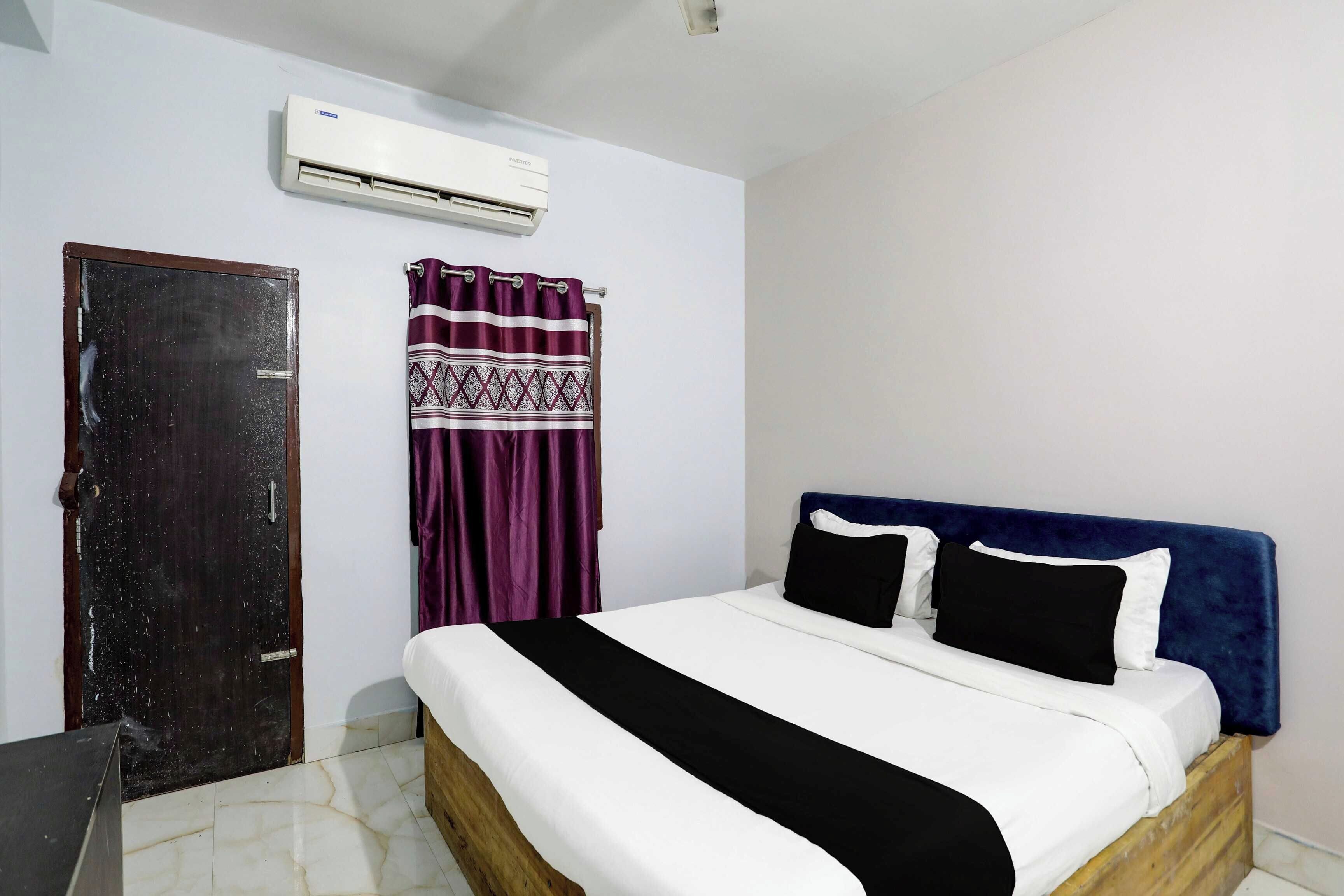 Un dormitorio con cama, una puerta, aire acondicionado y una cortina.