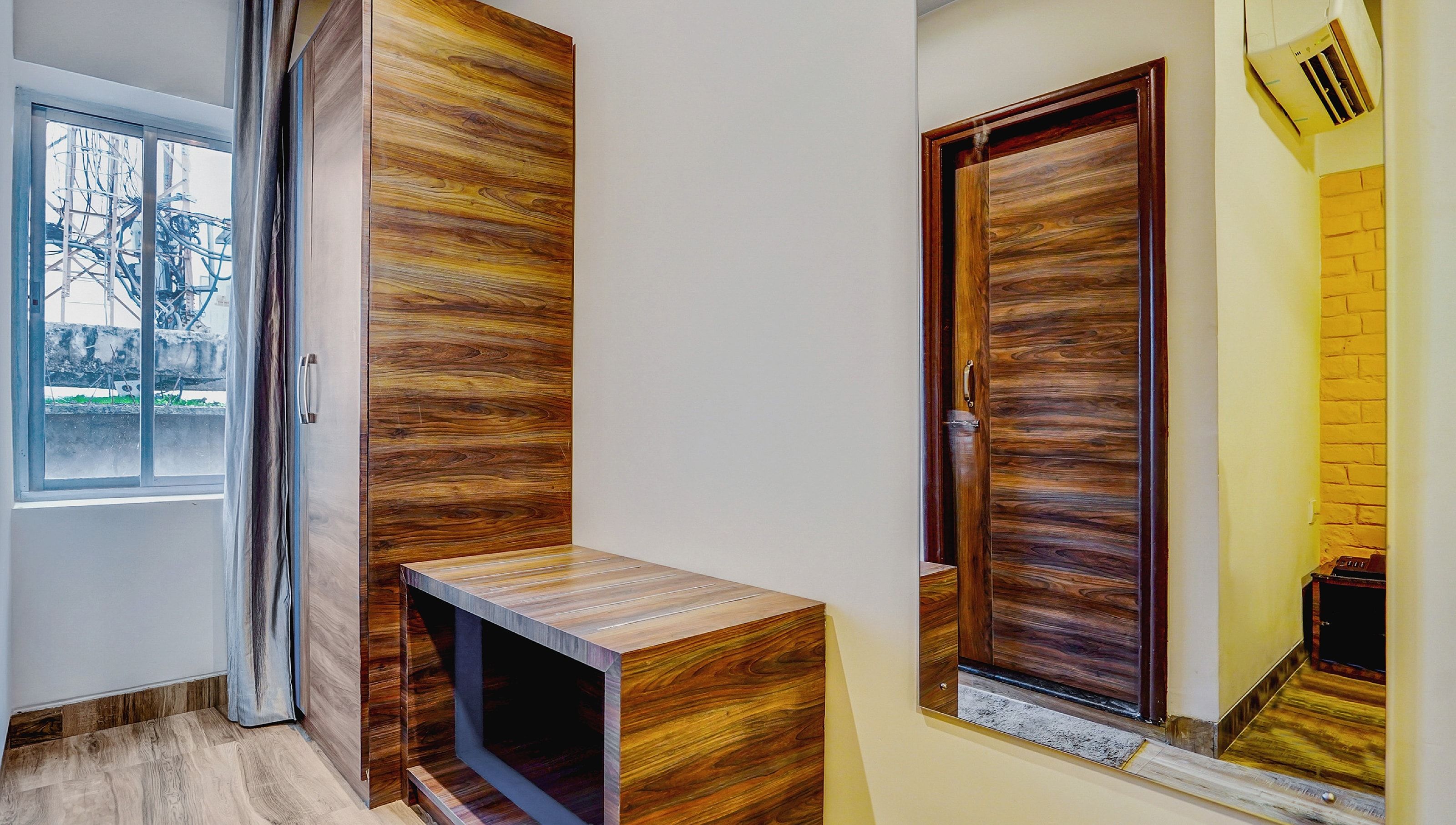 Un pasillo con un banco de madera, una puerta y una ventana.