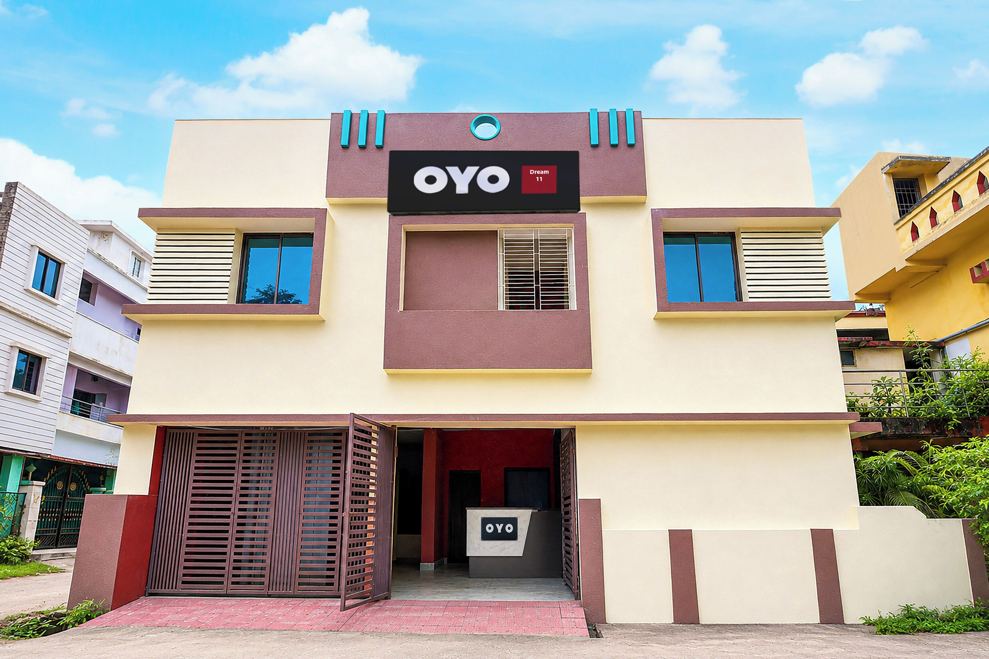 A modern building with a sign reading 'OYO' and 'Dream 11'.