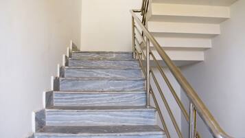 A staircase with marble steps and a metal handrail.