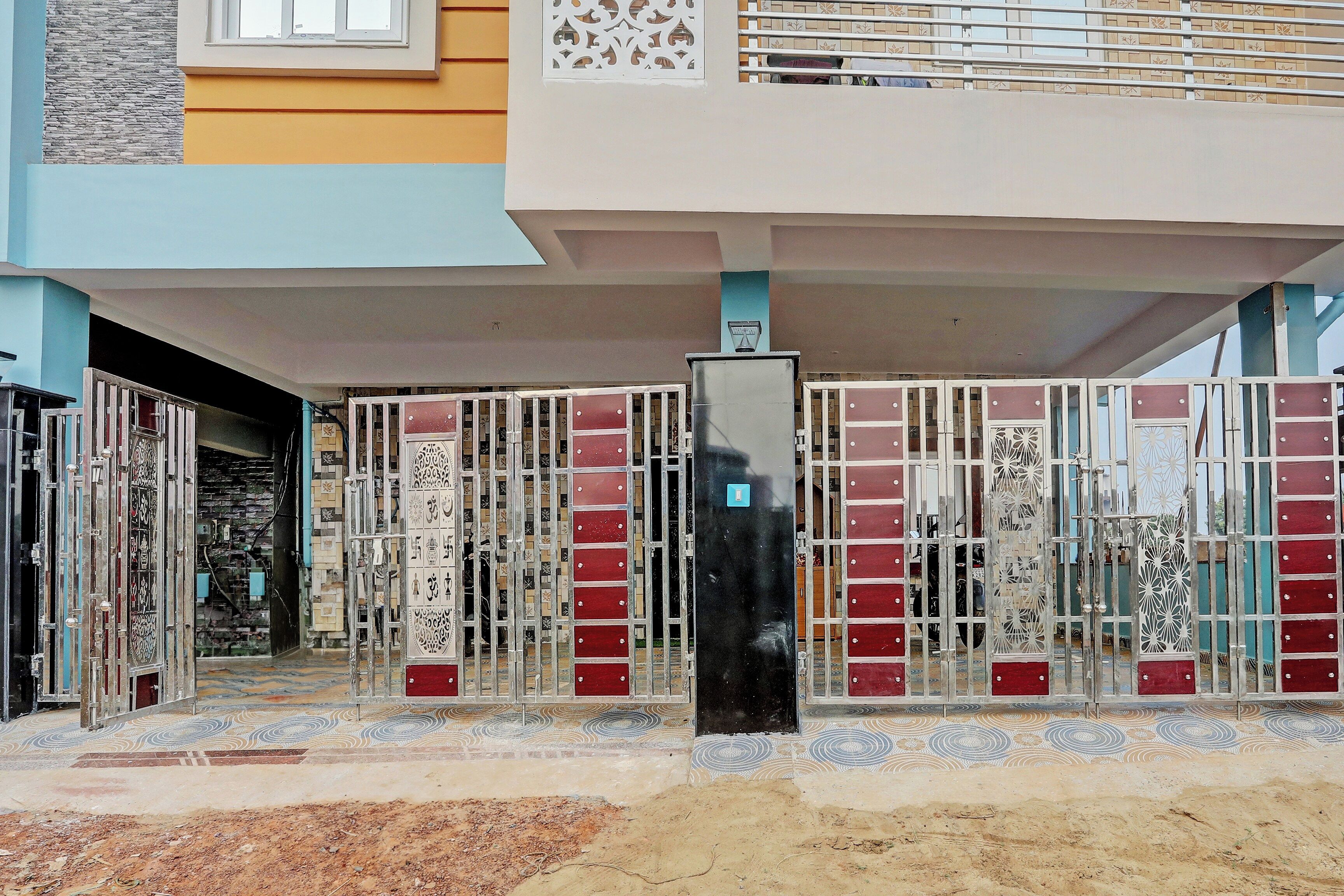 Una entrada con reja, adornada con detalles metálicos y un suelo de baldosas.