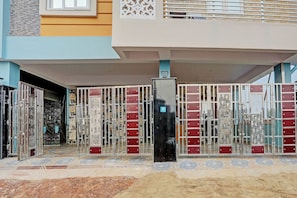 Uma entrada gradeada com detalhes em metal ornamental e piso de azulejos.