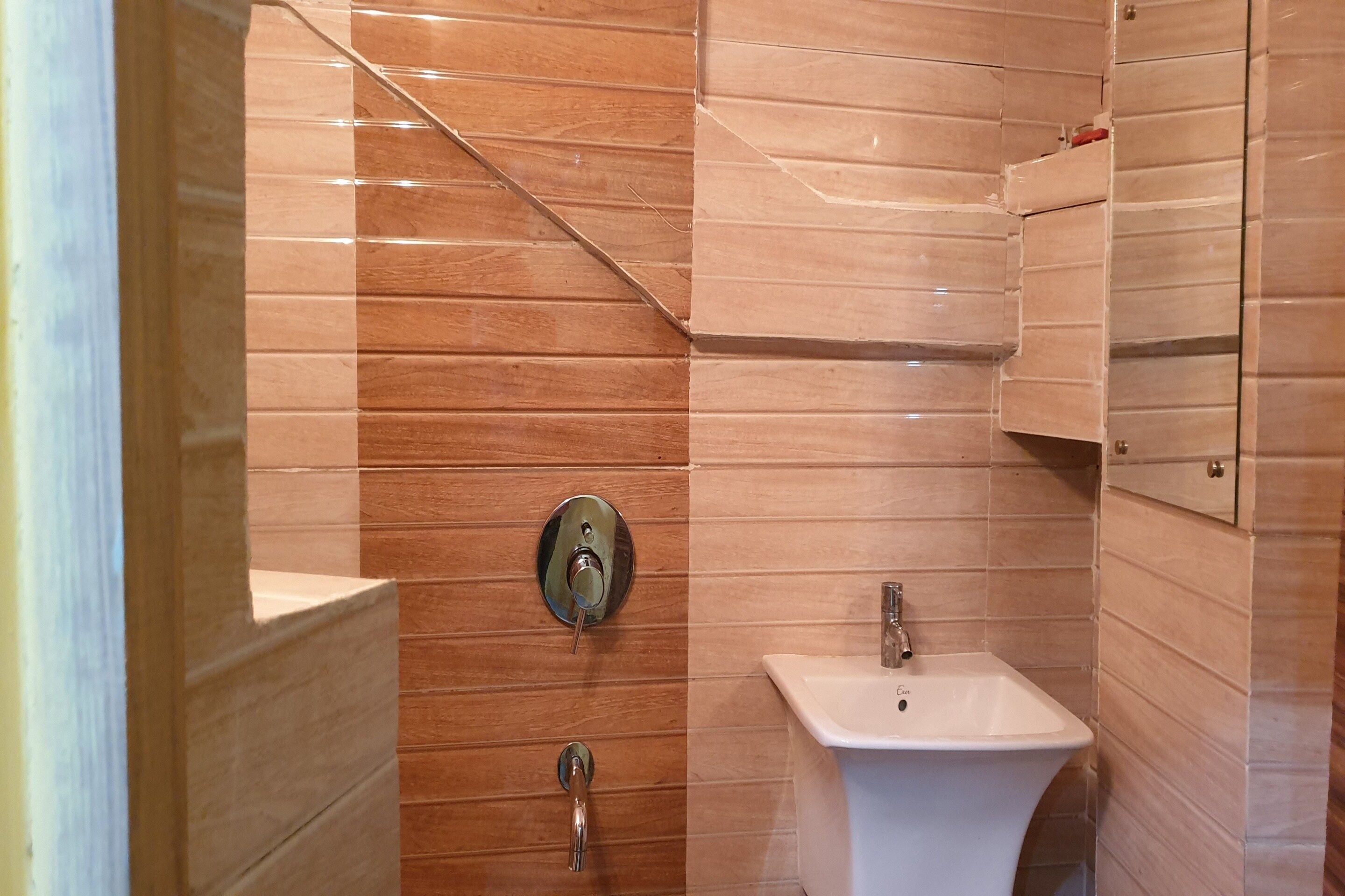 A bathroom with a white sink, a mirror, and a shower door.