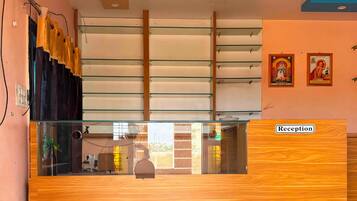 A reception desk with a wooden finish, glass panels, and a 'Reception' sign.
