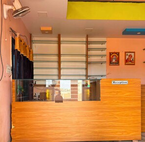 A reception desk with a wooden finish, glass panels, and a 'Reception' sign.