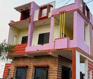 A multi-story building with a flat roof, balconies, and a brick facade.
