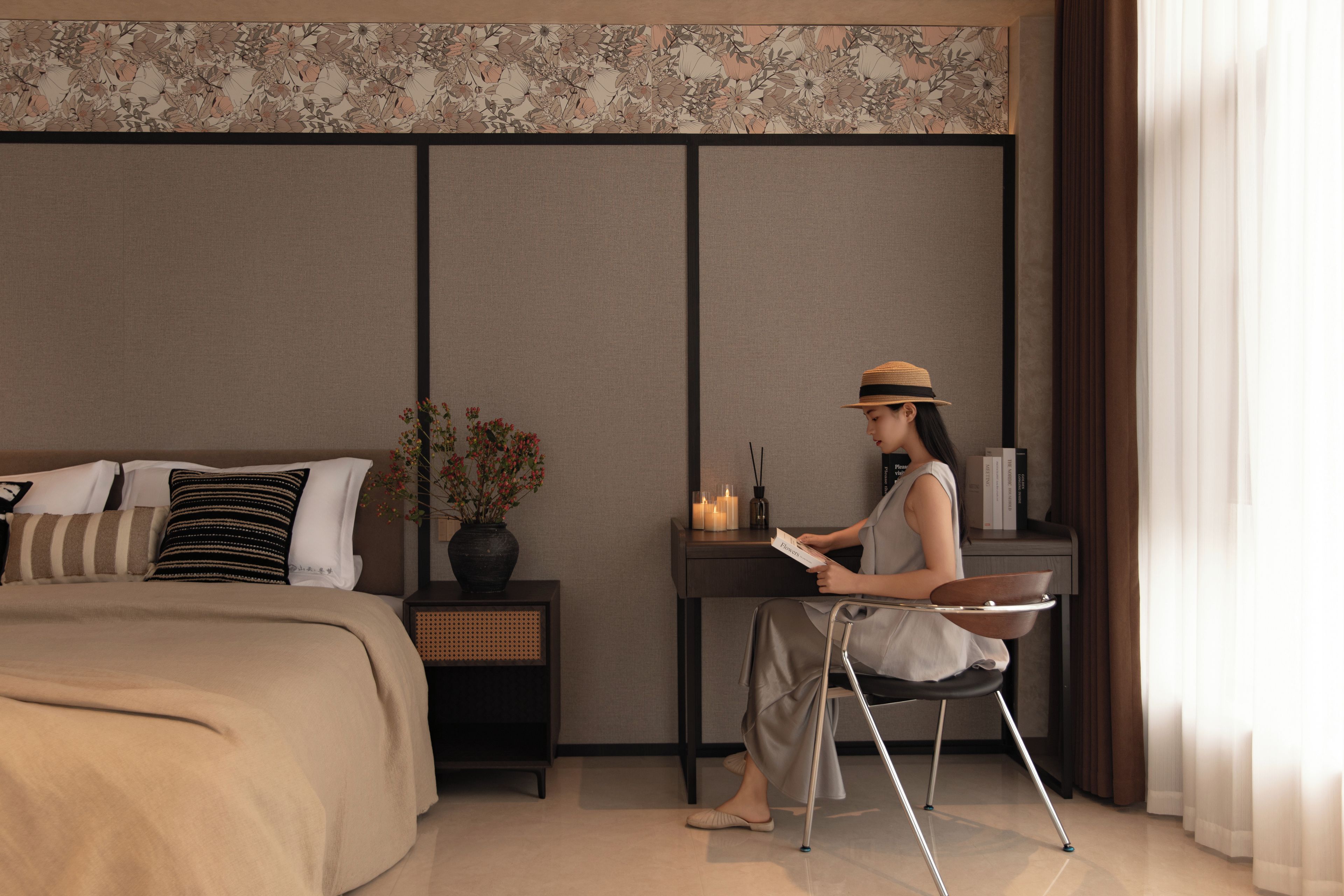 A modern bedroom with a bed, bedside table, and a reading chair.