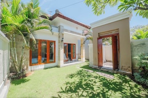 A residential property with a covered patio, a lawn, and a garden area. - Aluh Lovina Villa (Buleleng)