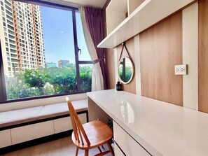 A room with a window, a desk, a chair, and a mirror. - Elegant Apartment at RiverGate Residence, Gym & Pool, Central of HCM City (Thành phố Hồ Chí Minh)