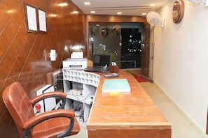 A conference room with a wooden table, office chairs, a desktop computer, and a printer. - Prince Malabar Residency (Secunderabad)