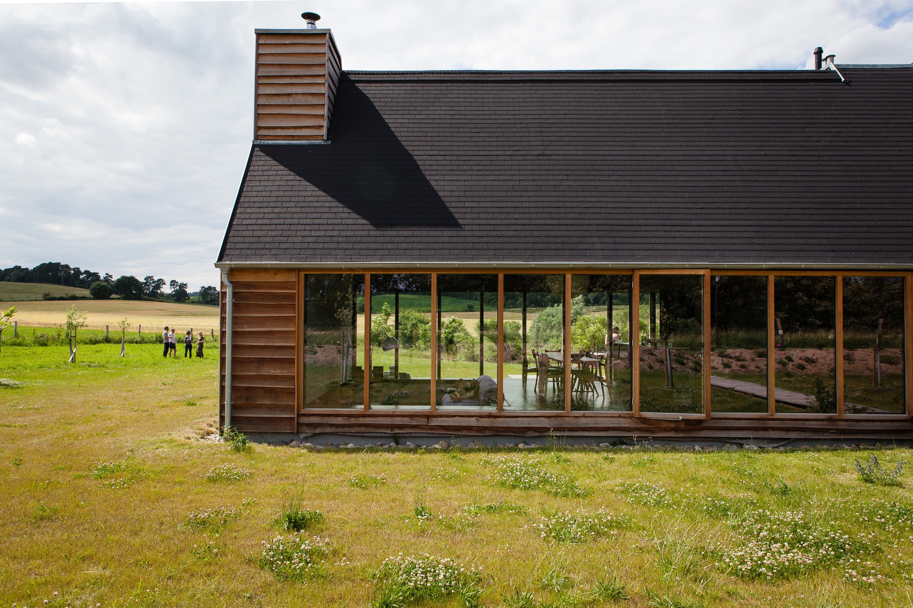 Un bâtiment moderne doté d’un toit en pente et de grandes fenêtres.